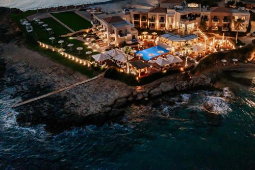 an aerial view of a resort with lights on the ocean at Alas Resort & Spa in Elia Laconias