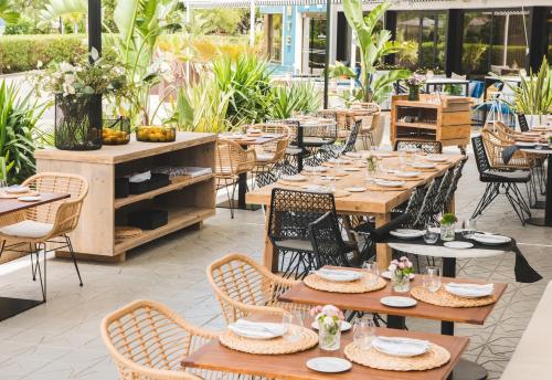a restaurant with wooden tables and chairs and plants at Hotel Almirante in Alicante