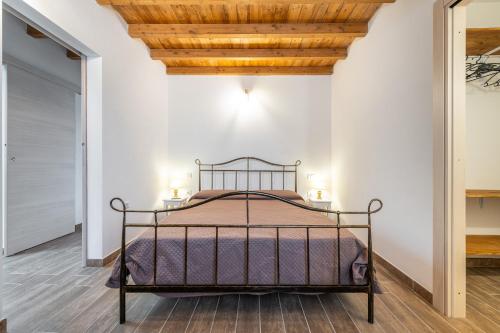 1 dormitorio con cama y techo de madera en Casa Giovanna, en San Giovanni Suergiu
