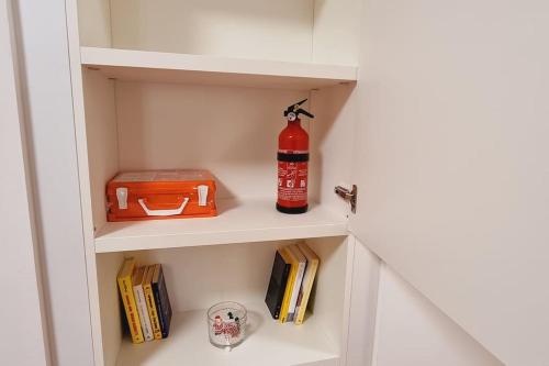 a fire extinguisher and books on a book shelf at My House&Apartments in Agrate Brianza