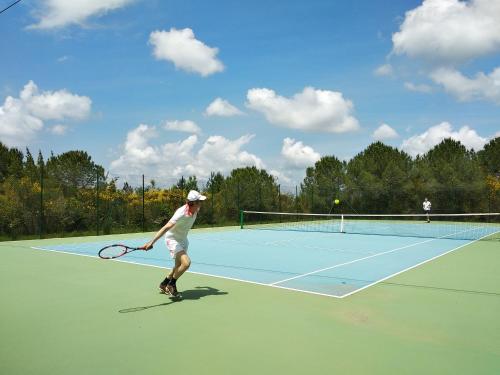 a man holding a tennis racket on a tennis court at Agriturismo Le Case di San Vivaldo in Montaione