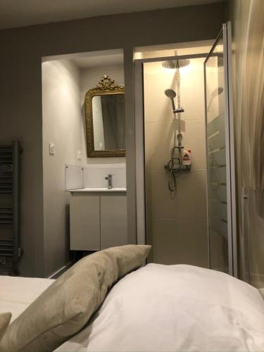 une salle de bain avec un lit, un lavabo et un miroir dans l'établissement L’atelier de Graslin, à Nantes