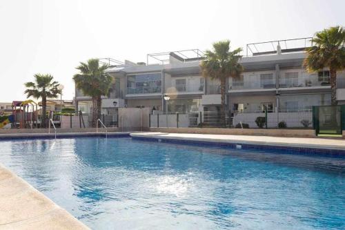 una gran piscina frente a un edificio en Bungalow Pink Oasis - Winter by the Sea, en Alicante