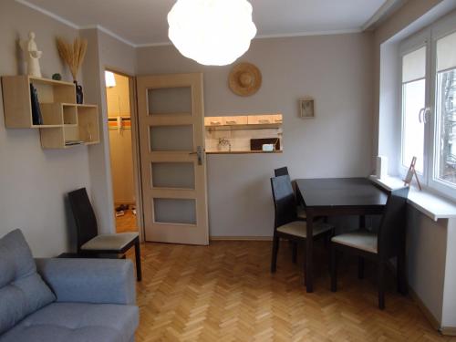 uma sala de estar com uma mesa e cadeiras e um sofá em Sunny Seven em Gdynia