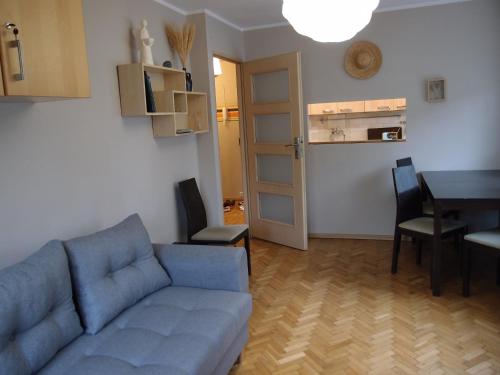 uma sala de estar com um sofá azul e uma mesa em Sunny Seven em Gdynia