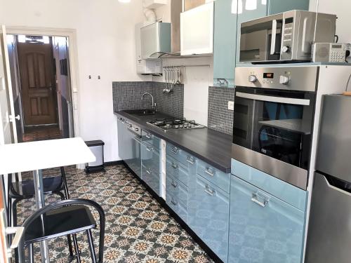 La cuisine est équipée de placards bleus et d'un four avec plaques de cuisson. dans l'établissement LE GALET - 500m de la Gare, à Les Sables-dʼOlonne