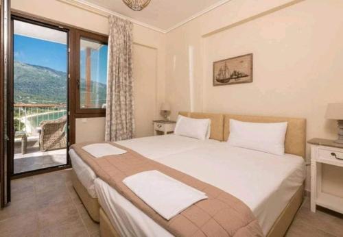 a bedroom with a bed and a large window at Seascape Villas Kinira - Elia & Anatoli in Kinira