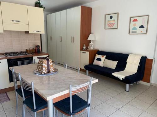 a kitchen and living room with a table and a couch at APPARTAMENTO CAMPO IMPERATORE in Castel del Monte