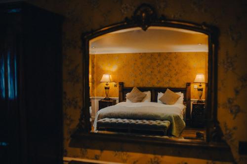um quarto com uma cama e um espelho grande em The George Hotel em Inveraray