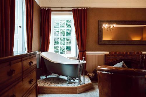 a bathroom with a bath tub in front of a window at The George Hotel in Inveraray