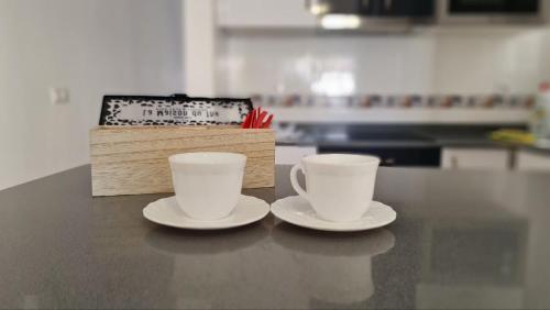 two coffee cups sitting on a counter with a box at El Olivar La Vega de Tetir in Tetir