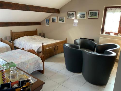 Le Castillon في Trivières: غرفة معيشة مع كرسيين وسرير