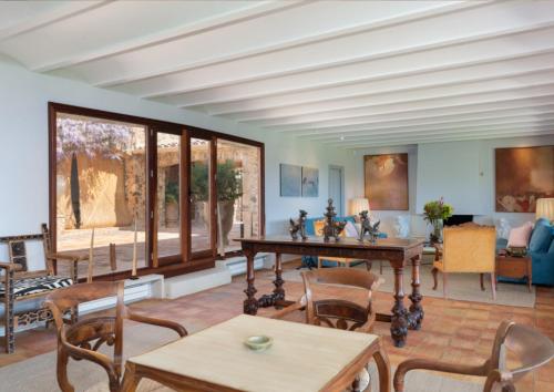 a living room with wooden tables and chairs at Finca Mas Gotas Costa Brava - BY EMERALD STAY in Vall-Llobrega