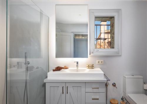 a white bathroom with a sink and a shower at Finca Mas Gotas Costa Brava - BY EMERALD STAY in Vall-Llobrega
