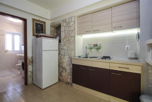 a kitchen with a white refrigerator and a sink at Apartment Leona 2216 in Premantura