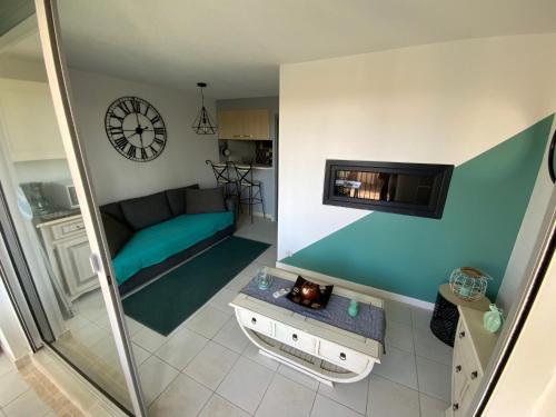 un salon avec un canapé et une télévision dans l'établissement appartement T2 climatisé avec piscine secteur richelieu, au Cap d'Agde
