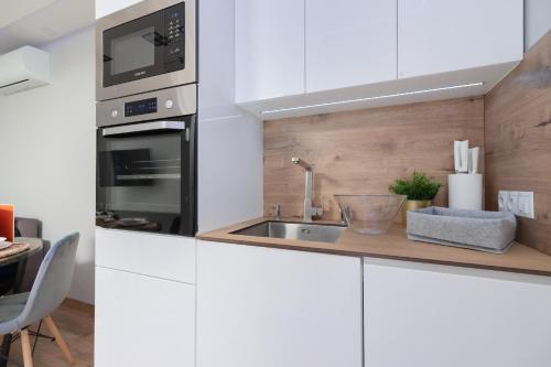 a kitchen with white cabinets and a sink at VIVA Apartment Mistrzejowice Klimatyzacja i Parking by Renters in Krakow