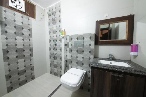 y baño con aseo, lavabo y espejo. en Grey Castle - Hotel Near Haridwar Railway station, en Haridwar