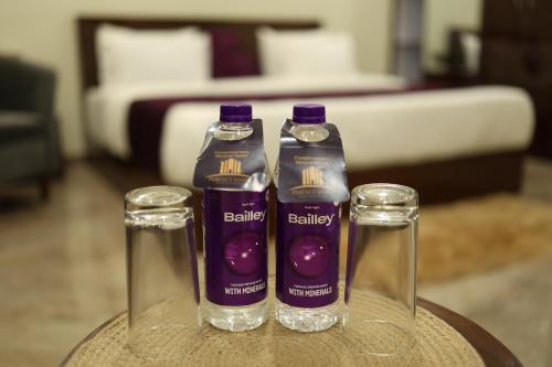 dos botellas de líquido púrpura sentadas en una mesa en Grey Castle - Hotel Near Haridwar Railway station, en Haridwar
