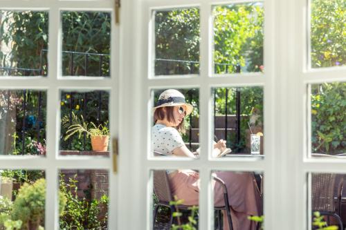 a woman sitting in a chair looking through a window at The Albany St Andrews in St. Andrews
