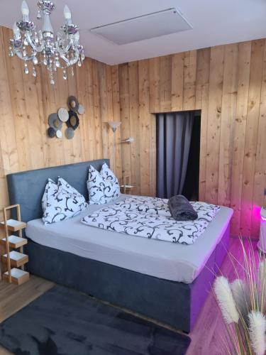 a bedroom with a bed and a chandelier at Bambu Lodge @ Ossiachersee in Bodensdorf