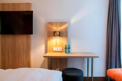 a hotel room with a small table with a television at ACHAT Hotel Stuttgart Airport Messe in Stuttgart