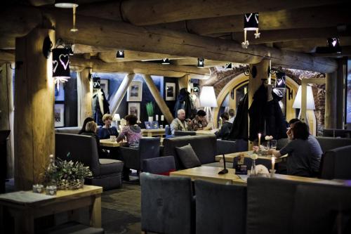 a restaurant with people sitting at tables and chairs at Piwnica Rycerska Kęty in Kęty