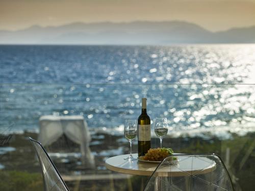 a table with a bottle of wine and two glasses at Alas Resort & Spa in Elia Laconias