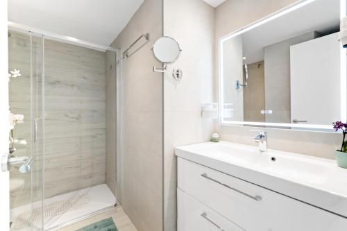 een witte badkamer met een wastafel en een douche bij Benalbeach Sea View in Benalmádena