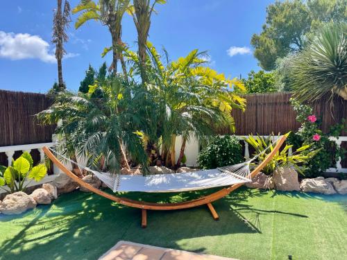 a hammock in the middle of a garden at Villa con piscina gigante in Sant Francesc de s'Estany