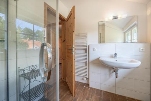 uma casa de banho branca com um lavatório e um espelho em Dorfstr_ OT Mueggenburg em Klein Kirr