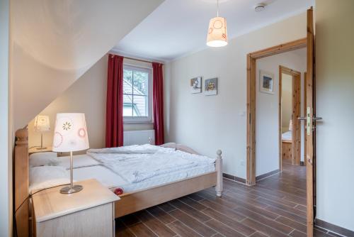 um quarto com uma cama e um candeeiro sobre uma mesa em Dorfstr_ OT Mueggenburg em Klein Kirr