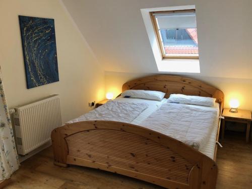 a bedroom with a large wooden bed with two lamps at Birkenstr_17 OG in Groß Kirr