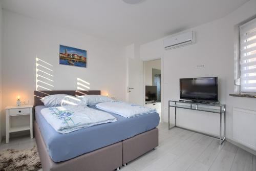 a bedroom with a bed and a flat screen tv at Apartment Vukadin in Pula
