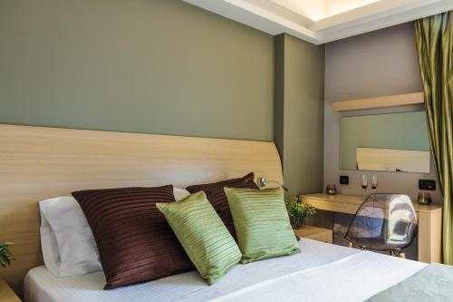 a bedroom with a bed with two green pillows at Alas Resort & Spa in Elia Laconias