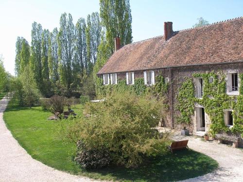 an old stone house with a garden in front of it at La Charbonnière in Tracy-sur-Loire