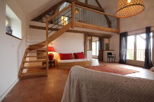een grote kamer met een hoogslaper en een bank bij La Charbonnière in Tracy-sur-Loire
