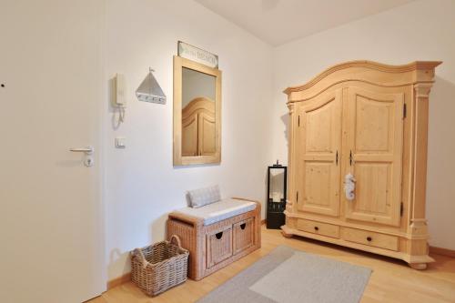 a room with a wooden cabinet and a mirror at Haus Strandstrasse Strandstrasse 150 Appartement 3 in Niendorf