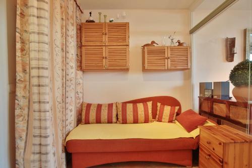 - une petite chambre avec un canapé et des placards en bois dans l'établissement Wohnpark Niendorf Wohnpark Niendorf Appartement 05, à Niendorf