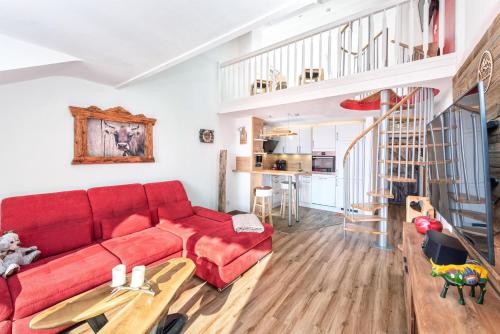 a living room with a red couch and a staircase at Alpenliebe-mit Bergblick in Oberstaufen