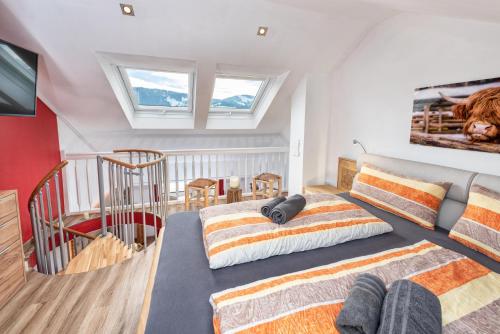 two beds in a bedroom with two windows at Alpenliebe-mit Bergblick in Oberstaufen
