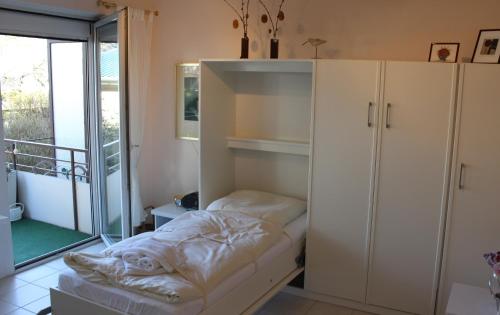 - une chambre avec un lit, une armoire et un balcon dans l'établissement DKK1b Ferienwohnung Stäcker F, à Niendorf