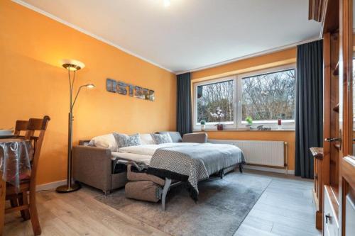 - une chambre avec un lit, un canapé et une fenêtre dans l'établissement Haus Meeresgruß, Appartement Flair, à Grömitz