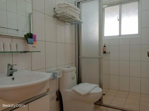 baño con lavabo y aseo y ventana en Oh! Yosuw BnB, en Chulu