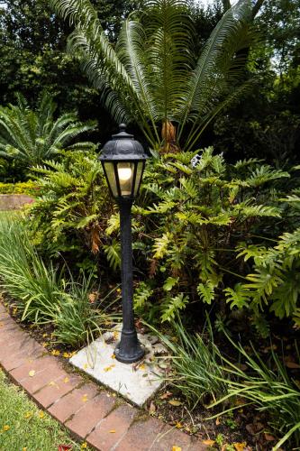 a black street light sitting on a brick path at Cape Village Lodge in Durbanville