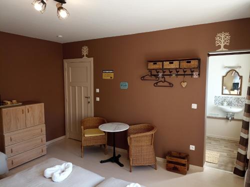 a bedroom with a sink and a table and chairs at Au Coeur d'Acren in Lessines