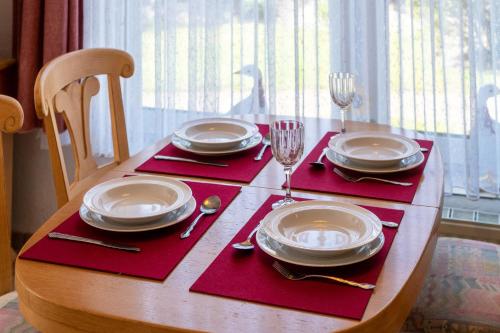 a wooden table with plates and glasses on top at Ferienhaus Seewind 11/1 in Werdum