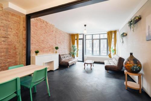 a living room with a brick wall and a table and chairs at Two-Bedroom Apartments in the Heart of Antwerp in Antwerp