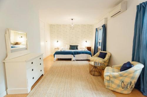 ein Schlafzimmer mit einem Bett, einem Sofa und einem Stuhl in der Unterkunft O&L Aire - Spacious and Bright Apartment in the Heart of Seville in Sevilla