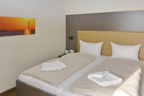 una camera da letto con un letto e due asciugamani di Resort Deichgraf Resort Deichgraf 27-01 a Wremen